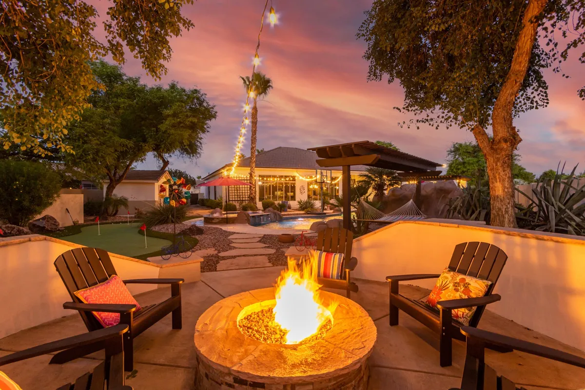 A cozy outdoor scene with a fire pit, comfortable seating, a hammock, and a landscaped garden, set up for evening gatherings, storytelling, or stargazing. The inviting atmosphere makes it ideal for relaxing after a day of adventure.